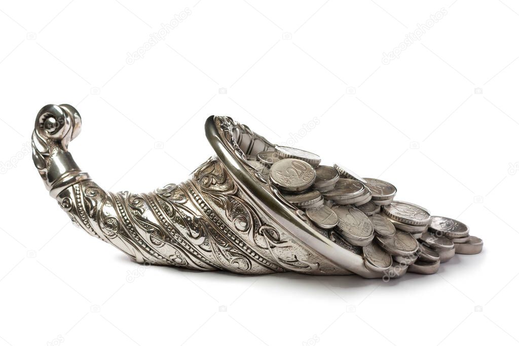 Silver coins pour out from the silver cornucopia. Isolated over white background. Side view.