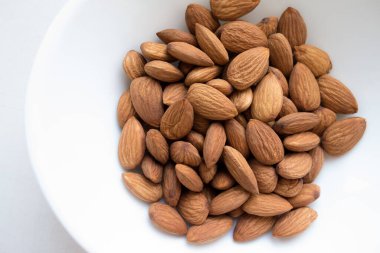 Beyaz tabakta badem taneleri.