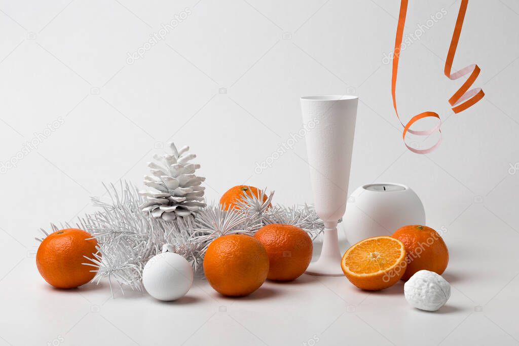 Christmas white still life with bright orange tangerines, a fir branch and Christmas tree decorations. New Year`s still life.