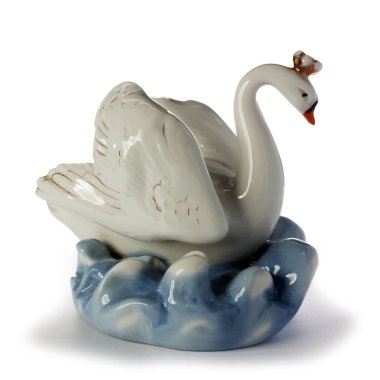 Kafasında kanatları yükselmiş ve dalgalarda yüzen bir taç olan porselen bir kuğu heykeli. Beyaz bir arka planda izole edilmiş. Yan görünüm.