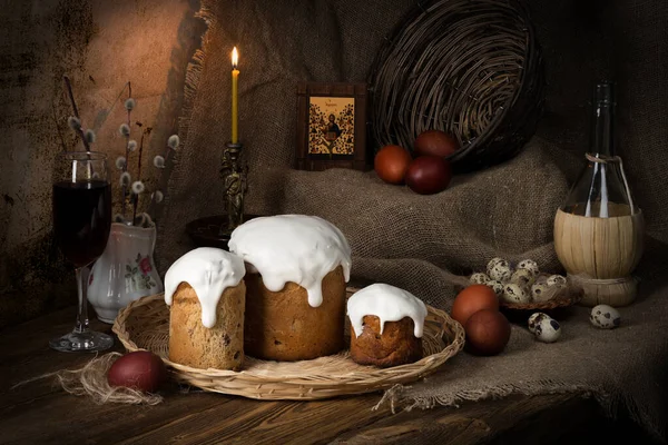 Easter vintage still life with cupcakes, painted eggs, pussy willow branches and a burning candle.