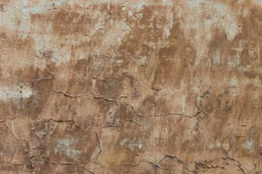 Boya kalıntıları, çatlaklar ve lekelerle dolu çimento harcı ile sıvanmış eski bir duvar. Grunge dokusu.