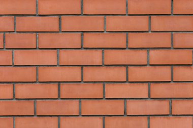 Wall surface of facing red brick with pronounced deepened seams close-up. Background texture.