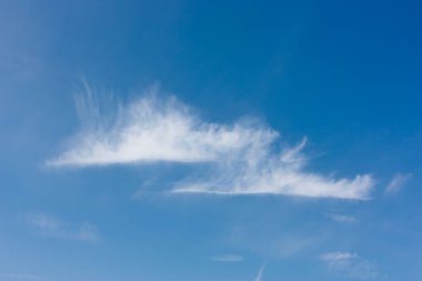 Mavi gökyüzünde iki sirrus bulutu. Gökyüzü deseni.