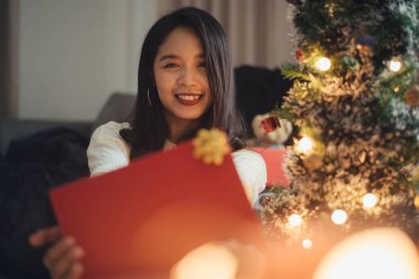 Noel 'i evde kutlamak için hediye kutusu gösteren bir kadın. Mutlu Noeller ve yeni yıl arifesi.