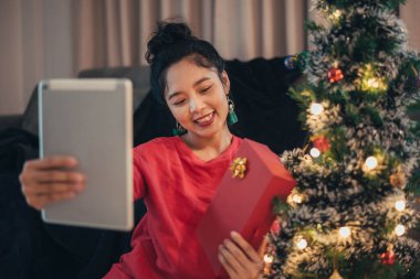 Sosyal ağda video görüşmesi yapan ve Noel günü Noel hediyesi veren bir kadın. Mutlu kız sosyal ağdan Noel 'i kutluyor.
