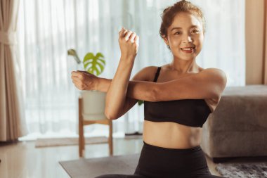 Evde yoga yapan genç bir kadın yoga yapıyor. Kadın evde yoga yapıyor..