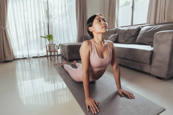 Young woman stretching after exercise at home. Fit woman workout at home. Home exercise.