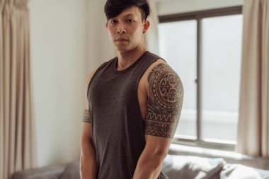 Formda adam evde egzersiz yapıyor. Spor giyimli genç adam evde spor yapıyor..