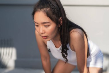 Genç bayan antrenmandan sonra dinleniyor. Sağlıklı Asyalı kadın antrenmana ara veriyor..