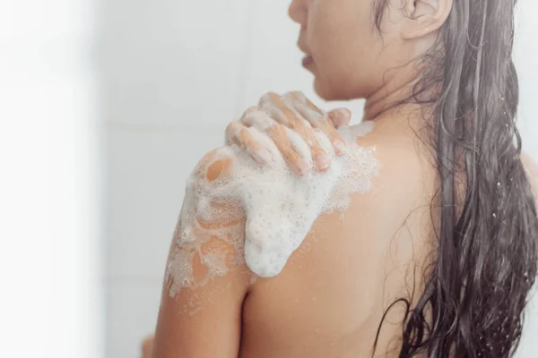 Young woman washing body in shower. Asian woman take a bath in bathroom.