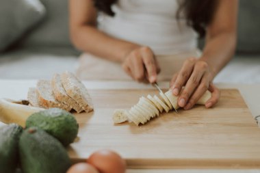 Ellerini yaklaştır ve babana 'yı kes. Evde sağlıklı yemek pişiren genç bir kadın. Sağlıklı ve sağlıklı olma kavramı.