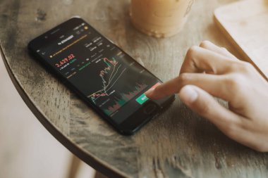 Ticari yatırımcı akıllı telefondan tartışıyor ve analiz ediyor. İş kadını şifreleme için cep telefonu uygulaması analizi kullanıyor.