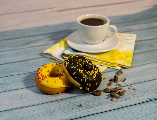 Aromatic coffee and fresh glazed doughnuts with sprinkles — Stock Photo, Image