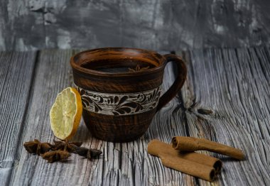 Bir fincan kil çay. Tarçın, yıldız anason ve kurutulmuş limon. Ahşap arkaplan