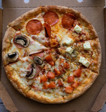 Domatesli, peynirli, mantarlı ve baharatlı 4 sezonluk pizza.