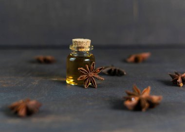 Koyu ahşap bir masanın üzerinde duran anason yağı kavanozu.