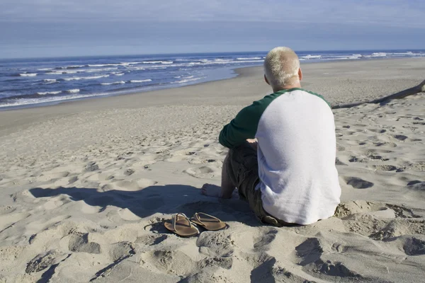 Genç adam okyanus izlerken — Stok fotoğraf