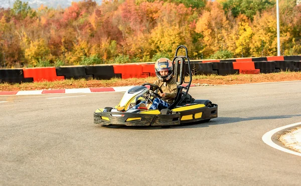 Little girl is driving Go- Kart car in a playground racing track