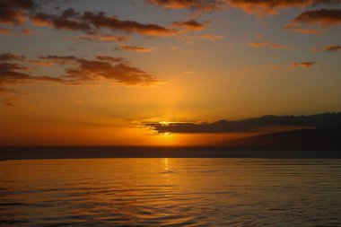 Atlantik okyanusu manzaralı havuz, turuncu gün batımı ve La Gomera adası.