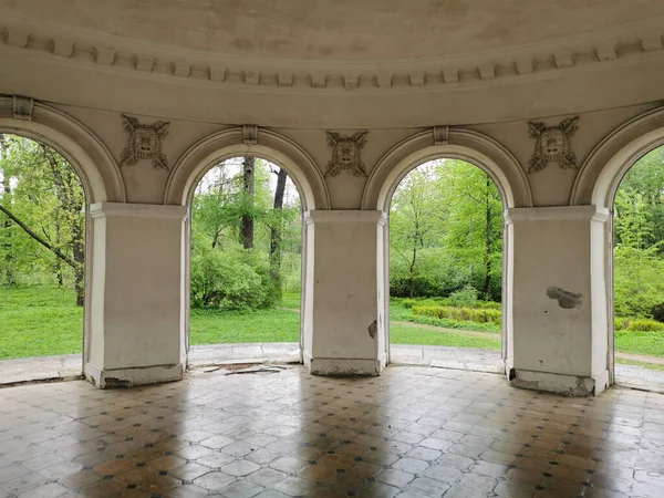Müzik Pavyonu içeriden, kemerlerin arasından St. Petersburg 'daki Elagin Adası' ndaki parktaki ağaçları ve otları görebilirsin.