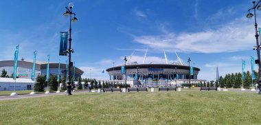 EURO 2020 Avrupa Futbol Şampiyonası 'nın olduğu sabah St. Petersburg' daki Gazprom Arena Stadyumu 'nun önündeki çimen ve banklar bulutlu mavi gökyüzüne karşı..