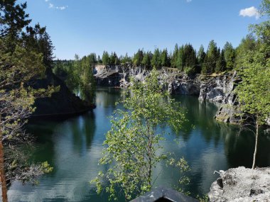 Ruskeala Dağ Parkı 'ndaki Mermer Kanyon' un zümrüt suyunun gözlem güvertesinden gökyüzünün yansıması ve bulutların berrak bir yaz gününde yansıması..