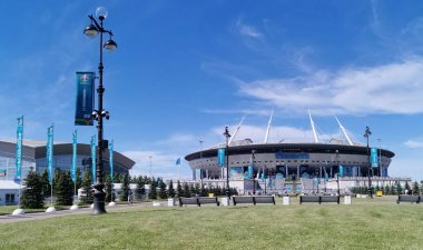 EURO 2020 Avrupa Futbol Şampiyonası 'nın olduğu sabah St. Petersburg' daki Gazprom Arena Stadyumu 'nun önündeki çimen ve banklar bulutlu mavi gökyüzüne karşı..