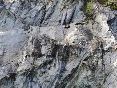 Güneşli bir yaz gününde Ruskeala Dağ Parkı 'ndaki su basmış Mermer Kanyon' un dik yamacı..