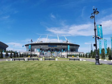 EURO 2020 Avrupa Futbol Şampiyonası 'nın olduğu sabah St. Petersburg' daki Gazprom Arena Stadyumu 'nun önündeki çimen ve banklar bulutlu mavi gökyüzüne karşı..
