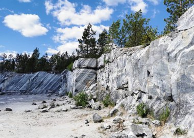 Güneşli bir yaz gününde Ruskeala Dağ Parkı 'nda pürüzsüz mermer parçalı İtalyan taş ocağı.