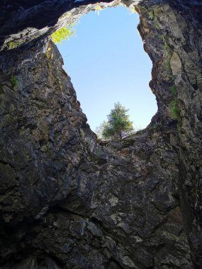 Bir yaz günü Ruskeala Dağ Parkı 'nda mermer madenciliğinde kullanılan dikey bir bacanın altından bir manzara..