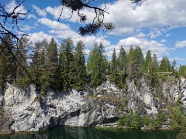 Güneşli bir yaz gününde Ruskeala Dağ Parkı 'ndaki Mermer Kanyon' un manzarası ve zümrüt suyu..