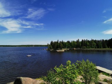 Vyborg şehrinin Monrepos Parkı 'ndaki Vyborg Körfezi' nin pitoresk sahilindeki gözlem güvertesinden mavi bulutlu bir gökyüzünün arka planına bakın..
