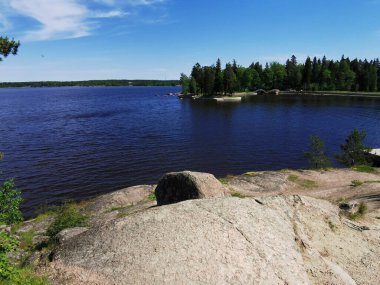 Vyborg şehrinin Monrepos Parkı 'ndaki Vyborg Körfezi' nin pitoresk sahilindeki gözlem güvertesinden mavi bulutlu bir gökyüzünün arka planına bakın..