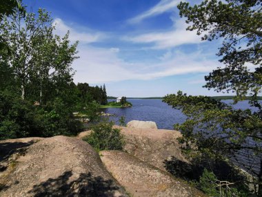 Vyborg şehrinin Monrepos Parkı 'ndaki Vyborg Körfezi' nin kıyısında duran Neptün Tapınağı 'nın görüntüsü bulutlu mavi gökyüzünün arka planına karşı..