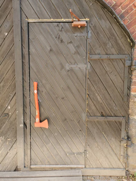 ヴィボルグ市のヴィボルグ城の石垣にあるカフェの赤い斧の形をしたハンドルを持つ茶色の木製のドア — ストック写真
