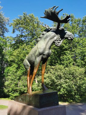Mavi gökyüzüne karşı Vyborg şehrindeki Lenin Park 'ta granit bir heykel üzerinde bronz bir Moose heykeli..