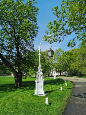 Ağaçlar, köşkler ve fenerler arasında ıssız bir yol sabah St. Petersburg 'daki Elagin Adası' ndaki bir parkta..