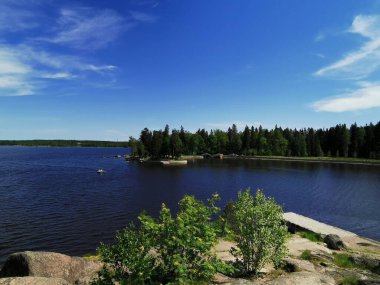 Vyborg şehrinin Monrepos Parkı 'ndaki Vyborg Körfezi' nin pitoresk sahilindeki gözlem güvertesinden mavi bulutlu bir gökyüzünün arka planına bakın..