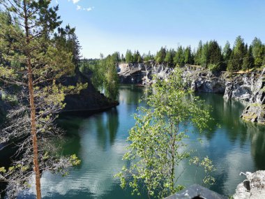 Ruskeala Dağ Parkı 'ndaki Mermer Kanyon' un zümrüt suyunun gözlem güvertesinden gökyüzünün yansıması ve bulutların berrak bir yaz gününde yansıması..