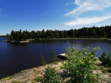 Vyborg şehrinin Monrepos Parkı 'ndaki Vyborg Körfezi' nin pitoresk sahilindeki gözlem güvertesinden mavi bulutlu bir gökyüzünün arka planına bakın..