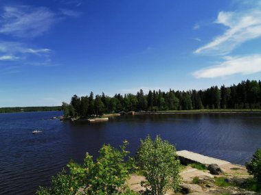 Vyborg şehrinin Monrepos Parkı 'ndaki Vyborg Körfezi' nin pitoresk sahilindeki gözlem güvertesinden mavi bulutlu bir gökyüzünün arka planına bakın..