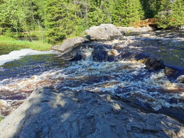 Karelia 'daki Tokhmayoki Nehri' ndeki kahverengi suyla kaynayan şelalenin manzarası ekolojik patikadan