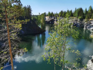 Ruskeala Dağ Parkı 'ndaki Mermer Kanyon' un zümrüt suyunun gözlem güvertesinden gökyüzünün yansıması ve bulutların berrak bir yaz gününde yansıması..