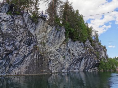 Güneşli bir yaz gününde Ruskeala Dağ Parkı 'ndaki Mermer Kanyon' un suyuna yansıyan mermer parçasının altından bir manzara..