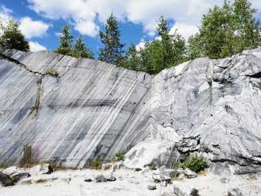 Güneşli bir yaz gününde Ruskeala Dağ Parkı 'nda pürüzsüz mermer parçalı İtalyan taş ocağı.