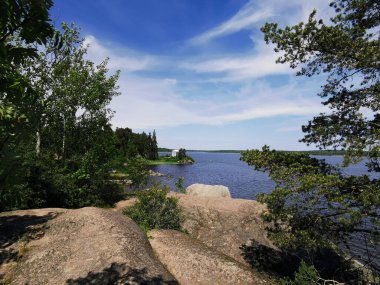 Vyborg şehrinin Monrepos Parkı 'ndaki Vyborg Körfezi' nin kıyısında duran Neptün Tapınağı 'nın görüntüsü bulutlu mavi gökyüzünün arka planına karşı..