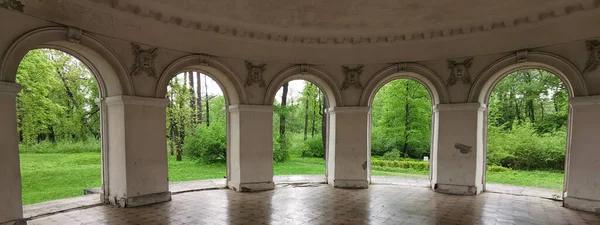 Müzik Pavyonu içeriden, kemerlerin arasından St. Petersburg 'daki Elagin Adası' ndaki parktaki ağaçları ve otları görebilirsin..