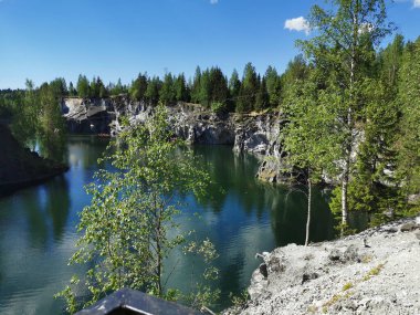 Ruskeala Dağ Parkı 'ndaki Mermer Kanyon' un zümrüt suyunun gözlem güvertesinden gökyüzünün yansıması ve bulutların berrak bir yaz gününde yansıması..
